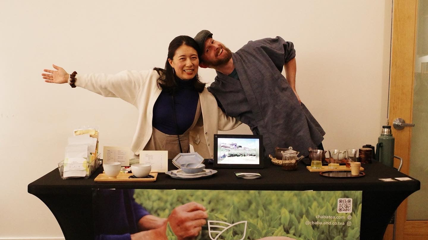 Two people posing behind a table with a 'Chaba & Co' branded backdrop.